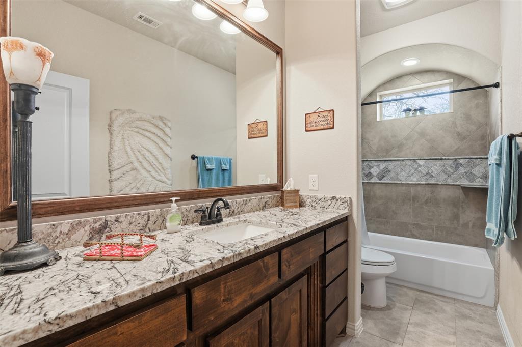 140 Flying Diamond Drive Springtown, TX 76082 - Photo 19 of 30 a bathroom with a granite countertop sink a toilet and shower