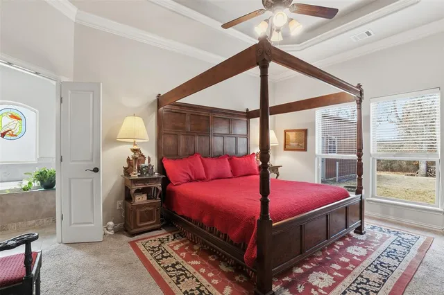 a bedroom with a bed a chandelier and a window