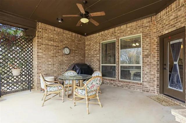 a patio with table and chairs and potted plants