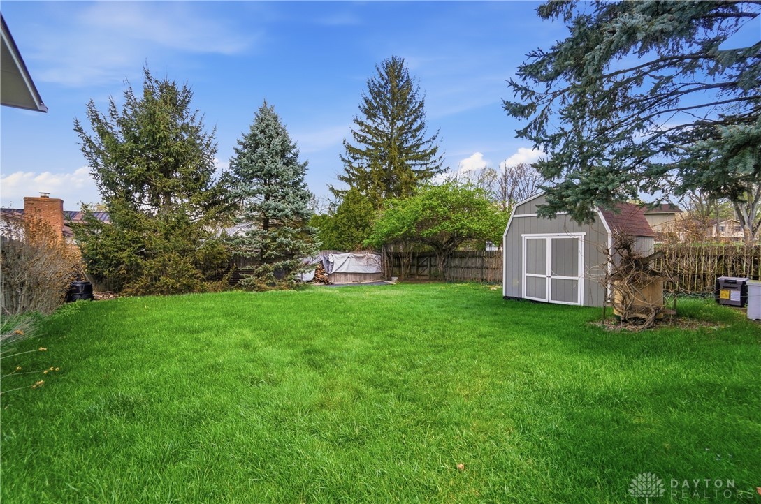 9964 Hummingbird Way Dayton, OH 45458 - Photo 52 of 57 This spacious backyard offers ample green space and a charming storage shed.