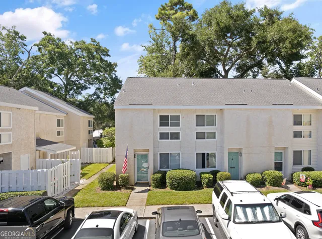 a view of a patio with couches table and chairs under an umbrella