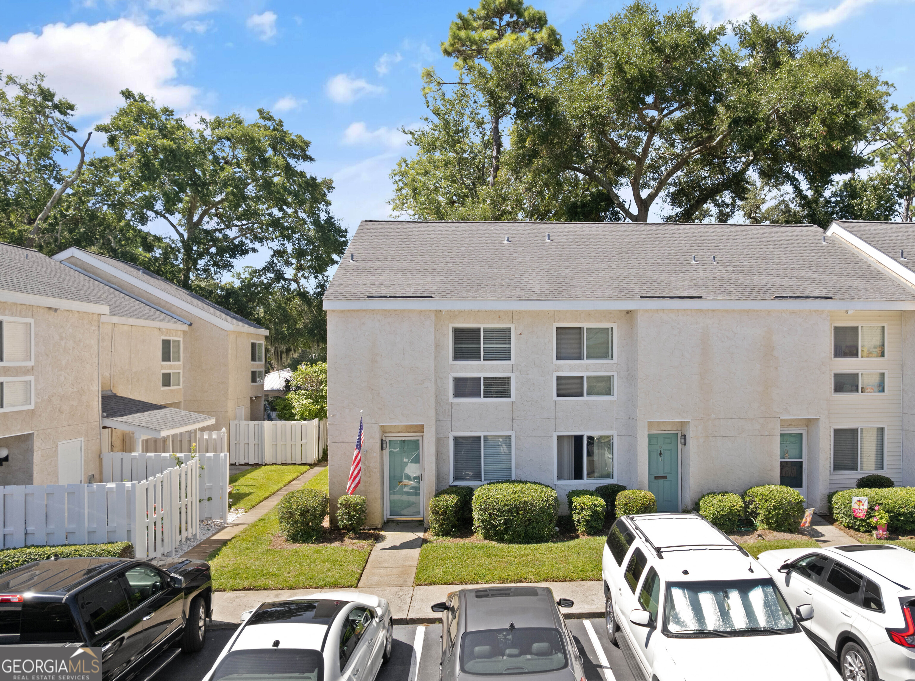 a view of a patio with couches table and chairs under an umbrella