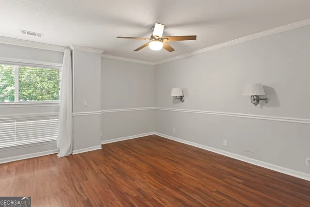 a view of an empty room with wooden floor fireplace and a window
