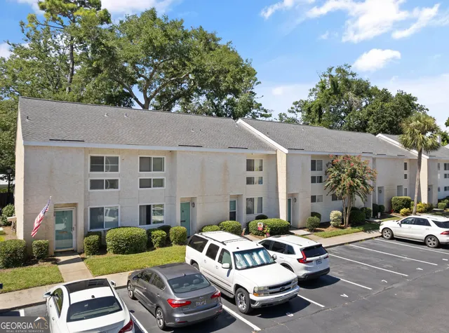 a view of a patio with couches and table and chairs with wooden fence