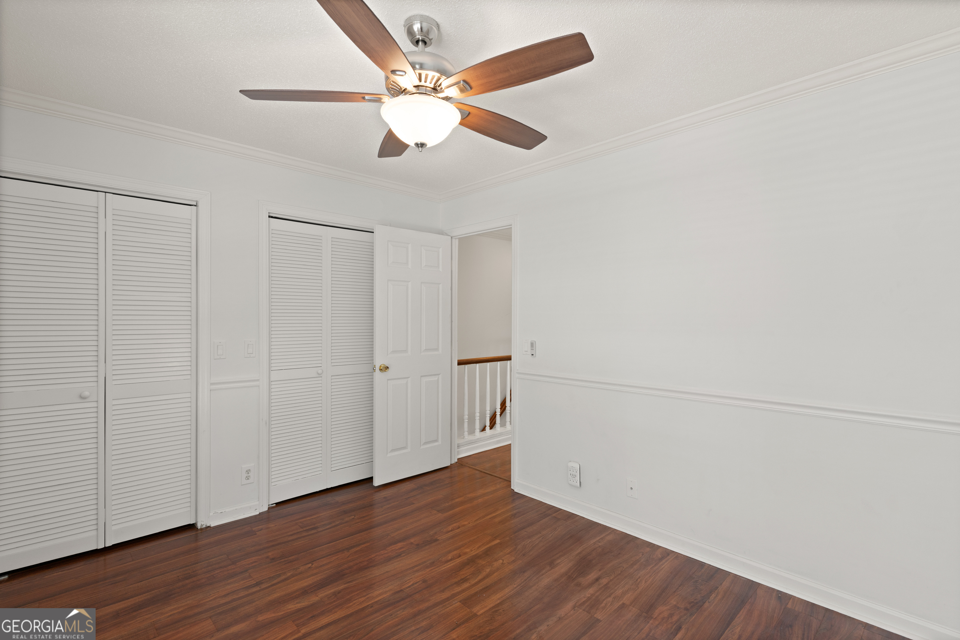 1000 Mallery St Extension, Unit B5 St. Simons, GA 31522 - Photo 22 of 24 an empty room with wooden floor fan and windows