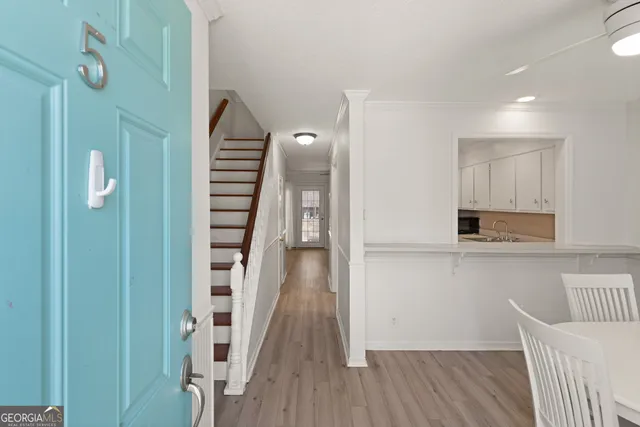 a view of a hallway with wooden floor and staircase