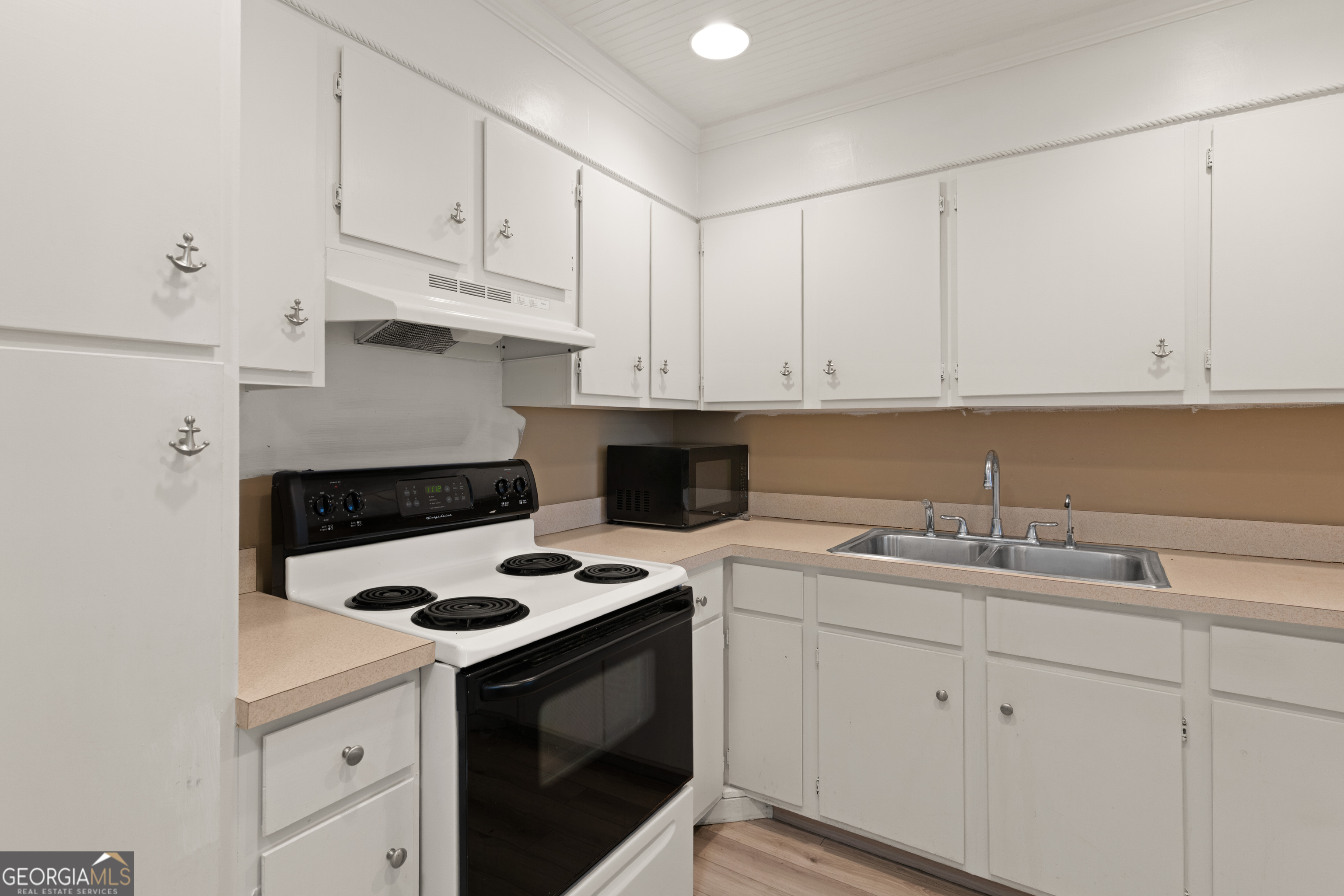1000 Mallery St Extension, Unit B5 St. Simons, GA 31522 - Photo 9 of 24 a kitchen with cabinets appliances a sink and a stove