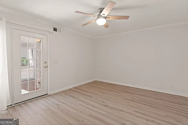 a view of an empty room with wooden floor