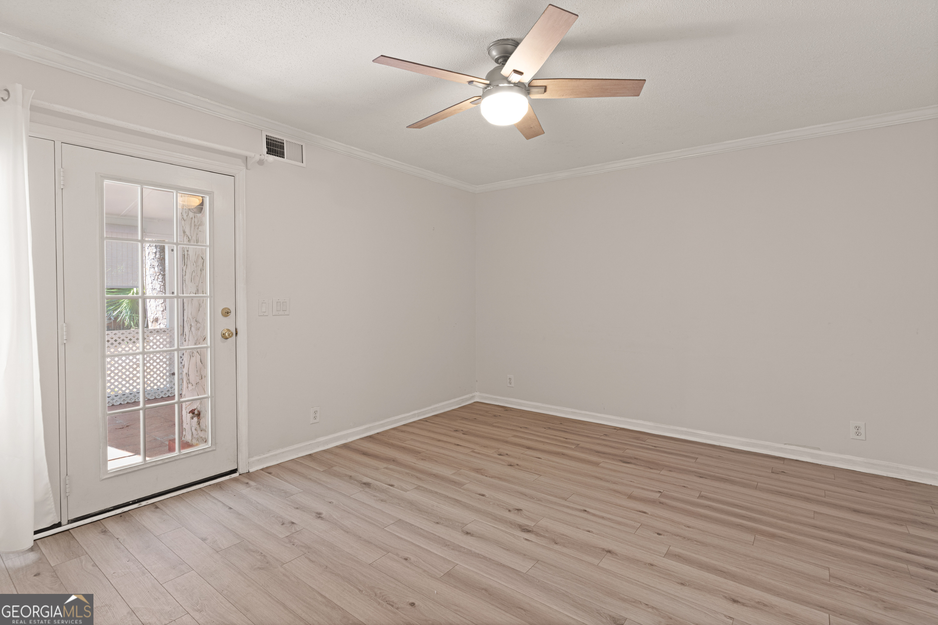 1000 Mallery St Extension, Unit B5 St. Simons, GA 31522 - Photo 10 of 24 an empty room with wooden floor fan and windows