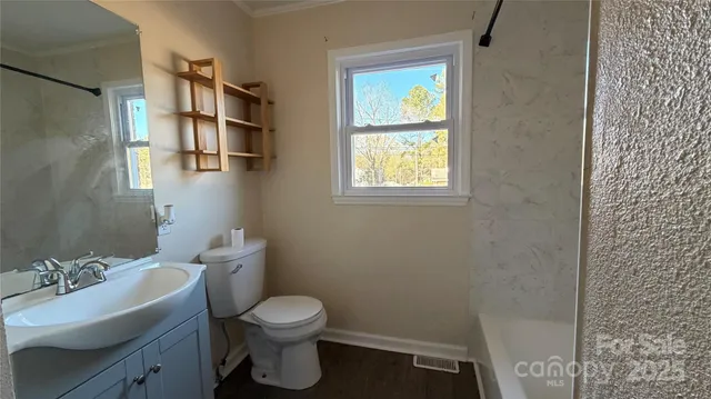 a bathroom with a sink toilet and window