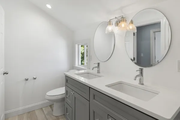 a bathroom with a toilet sink and mirror
