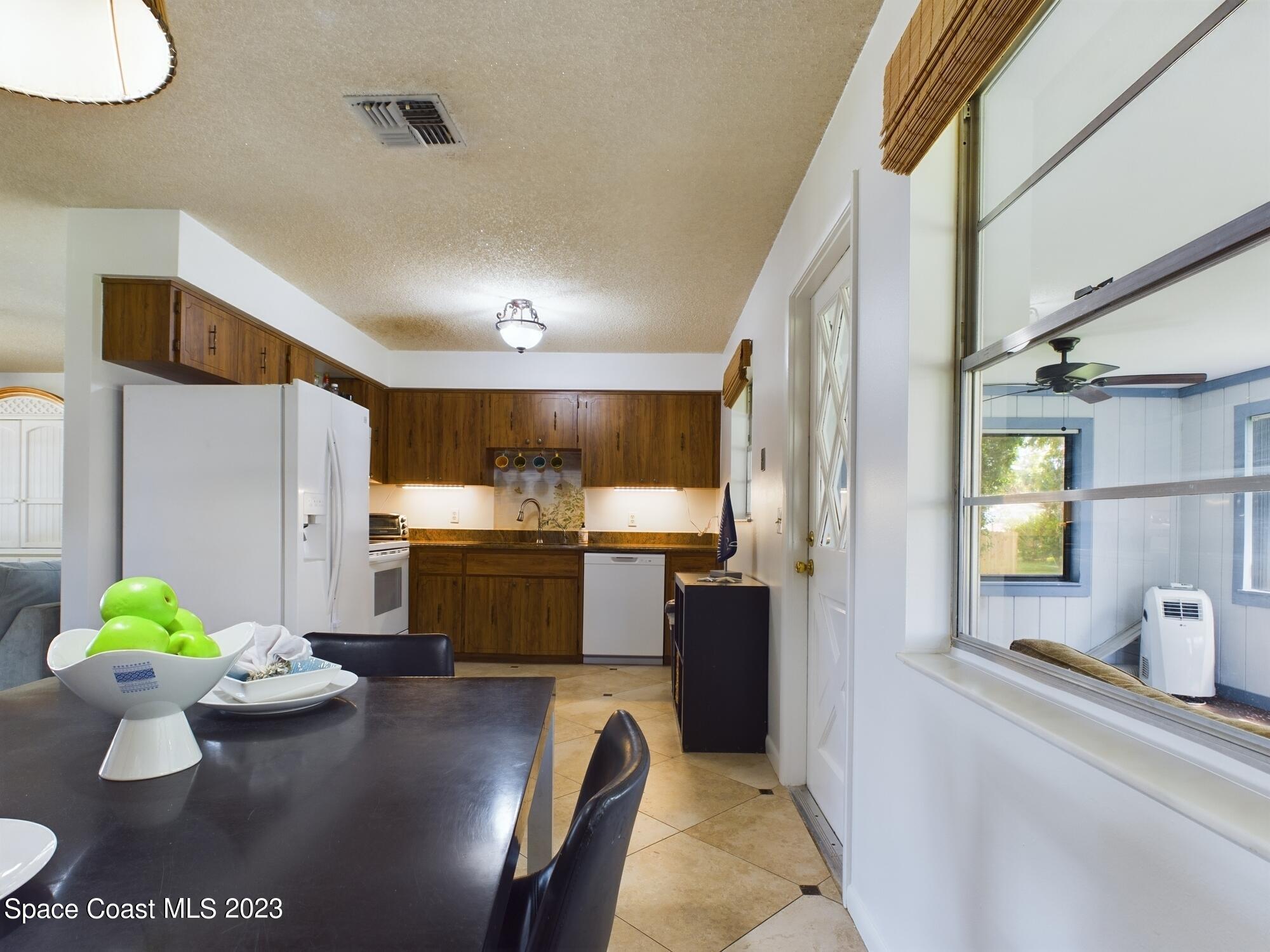 344 Columbus Street Sebastian, FL 32958 - Photo 15 of 35 a kitchen with stainless steel appliances kitchen island granite countertop a refrigerator and a stove