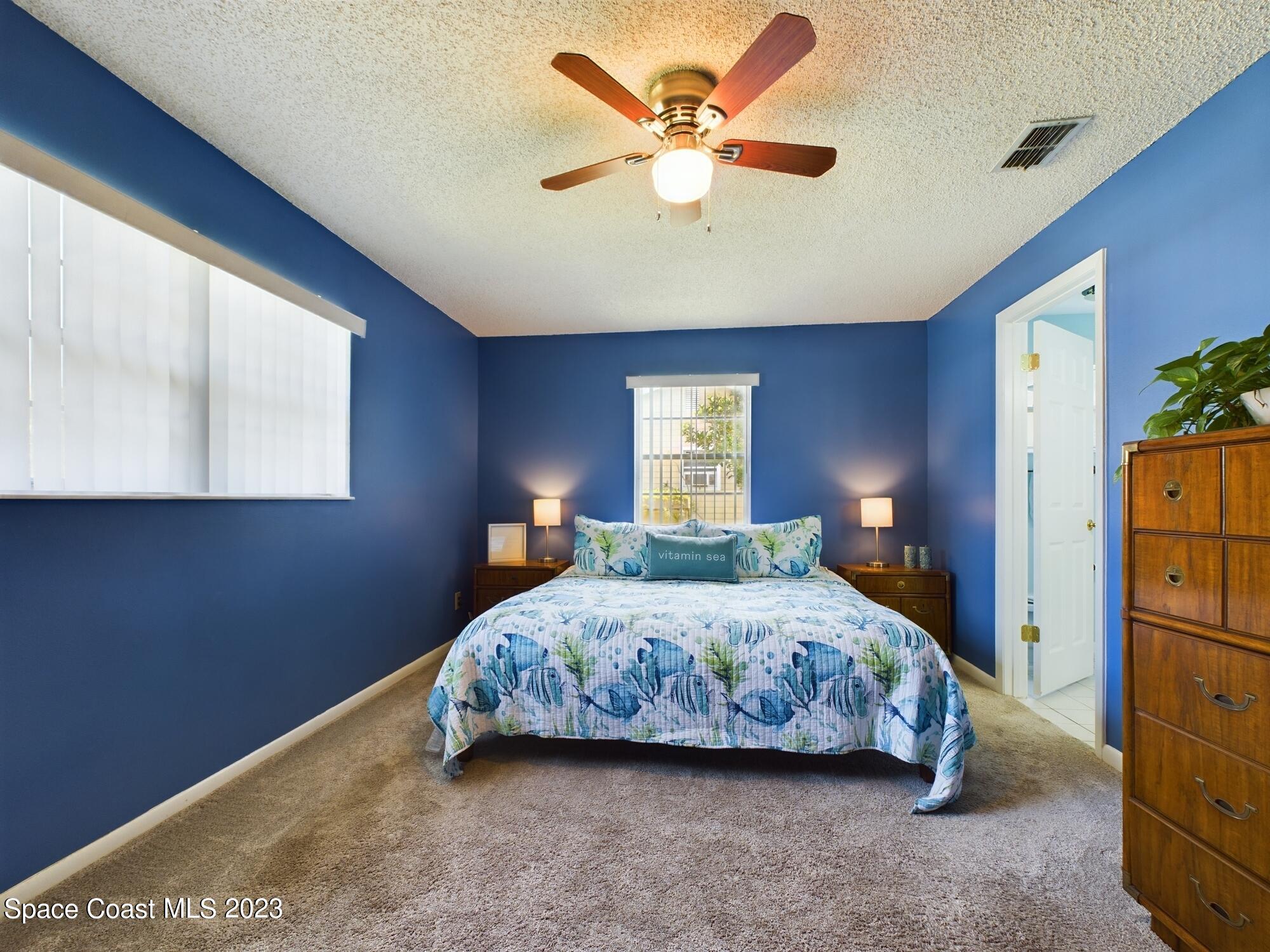 344 Columbus Street Sebastian, FL 32958 - Photo 31 of 35 a bedroom with a bed a window and a chandelier