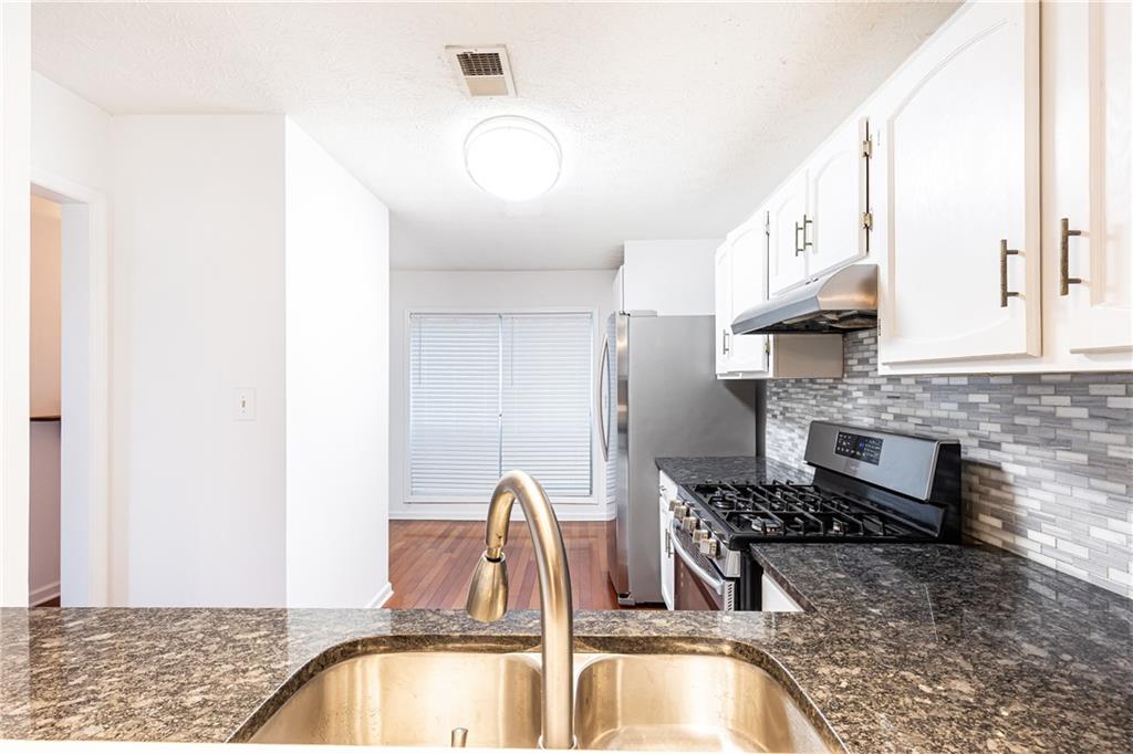2901 Lenox Way Northeast, Unit 902 Atlanta, GA 30324 - Photo 13 of 34 a kitchen with stainless steel appliances granite countertop a sink and a stove