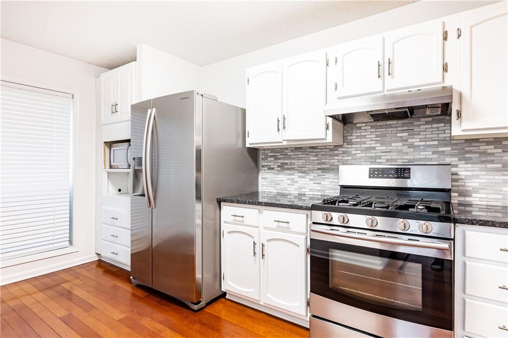 2901 Lenox Way Northeast, Unit 902 Atlanta, GA 30324 - Photo 15 of 34 a kitchen with granite countertop cabinets stainless steel appliances and wooden floor