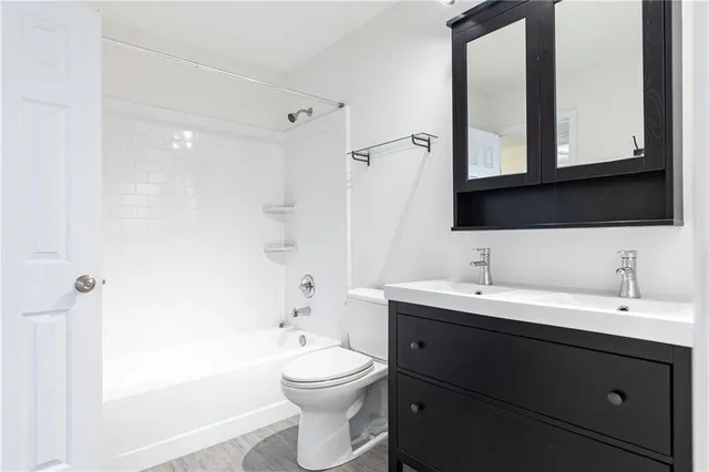 a bathroom with a toilet a sink and mirror