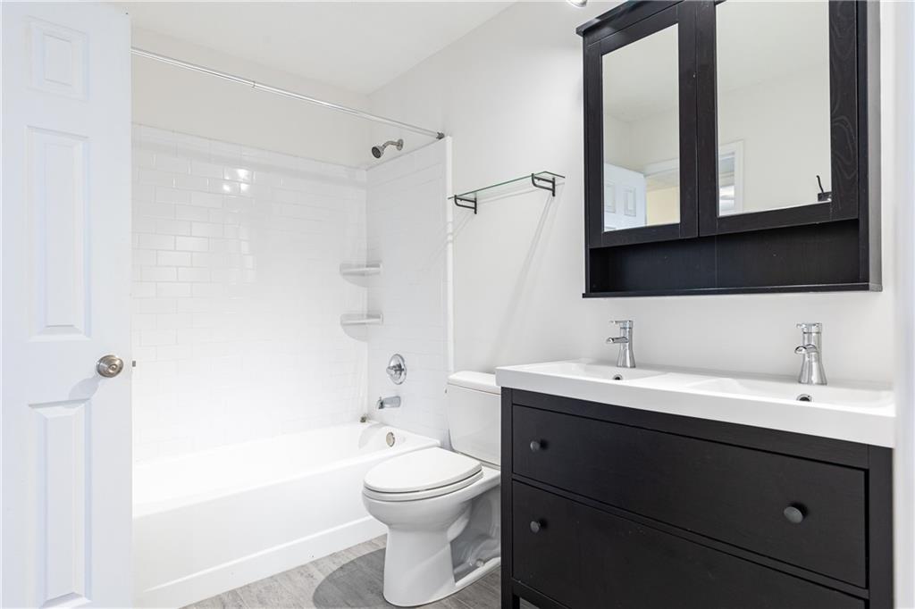 2901 Lenox Way Northeast, Unit 902 Atlanta, GA 30324 - Photo 26 of 34 a bathroom with a toilet a sink a mirror a bathtub and vanity