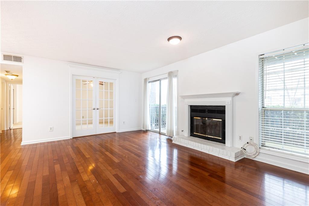 2901 Lenox Way Northeast, Unit 902 Atlanta, GA 30324 - Photo 6 of 34 an empty room with wooden floor fireplace and windows