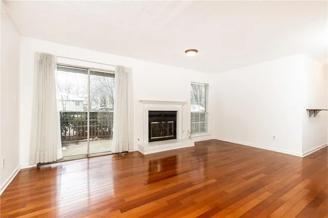 an empty room with wooden floor and fireplace