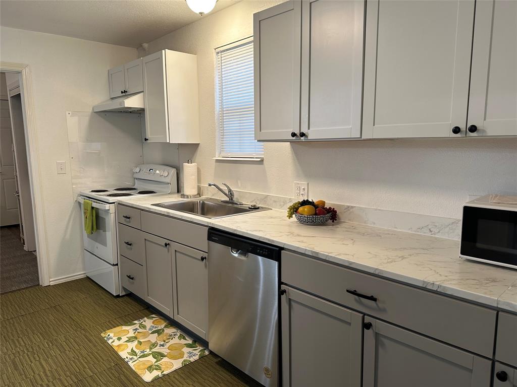 144 Huntoon Trail Mabank, TX 75156 - Photo 3 of 8 a kitchen with stainless steel appliances granite countertop a sink a stove and cabinets