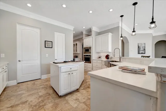 a large room with kitchen island a stove a sink a center island and furniture