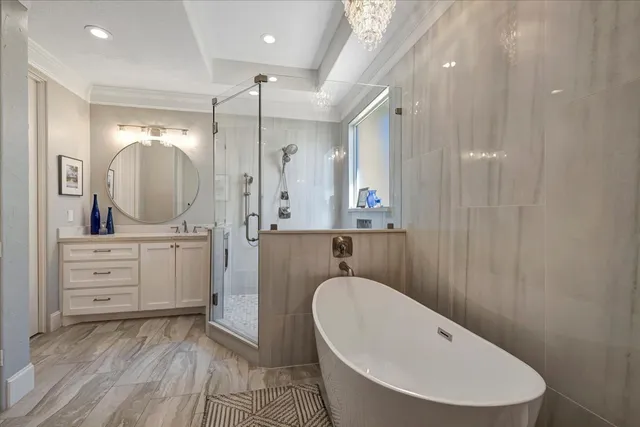 a bathroom with a tub a window and a chandelier