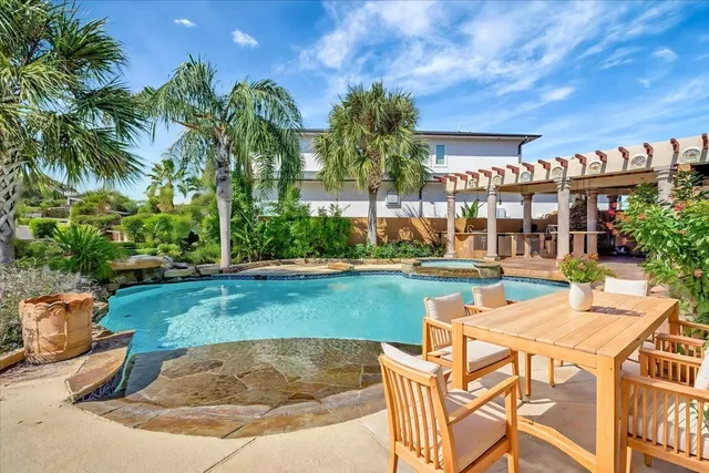 a view of a house with swimming pool and sitting area