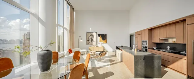 a living room with furniture and floor to ceiling windows