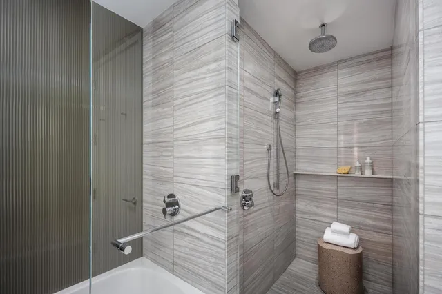 a bedroom with a bed and a large window with the outer view