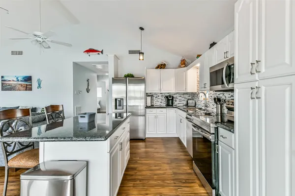 a kitchen with stainless steel appliances granite countertop a stove a sink and a refrigerator