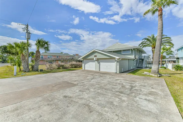 a view of large house with a yard and palm trees