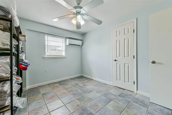 an empty room with windows and ceiling fan