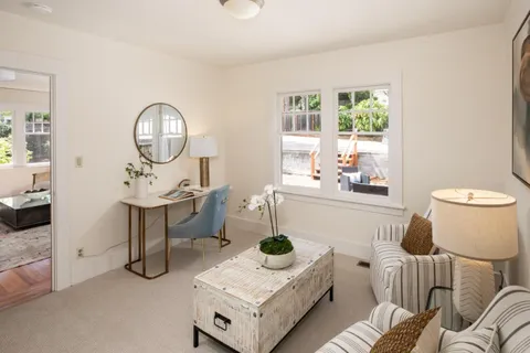 a living room with furniture a window and a potted plant