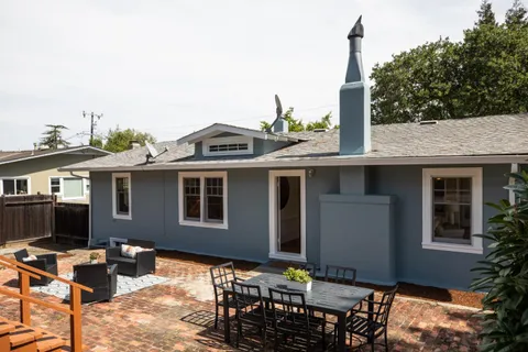a backyard of a house with table and chairs