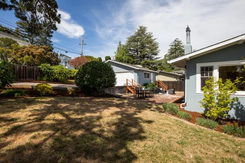 a view of a house with backyard and sitting area