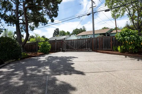 a view of backyard with wooden fence
