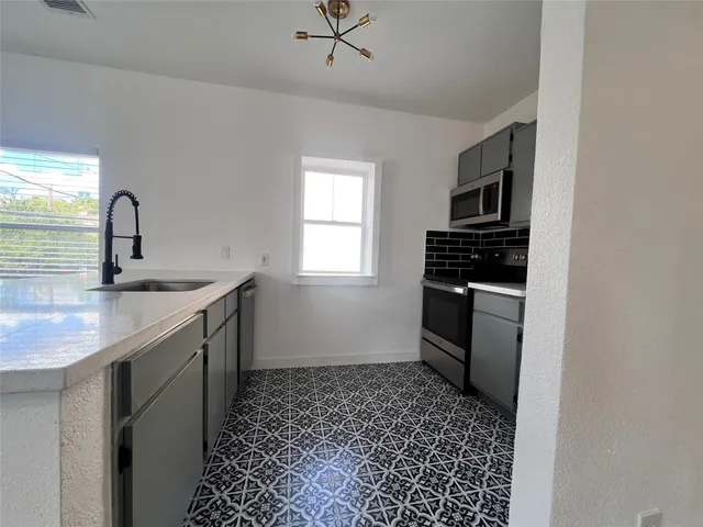 a kitchen with a sink appliances and cabinets