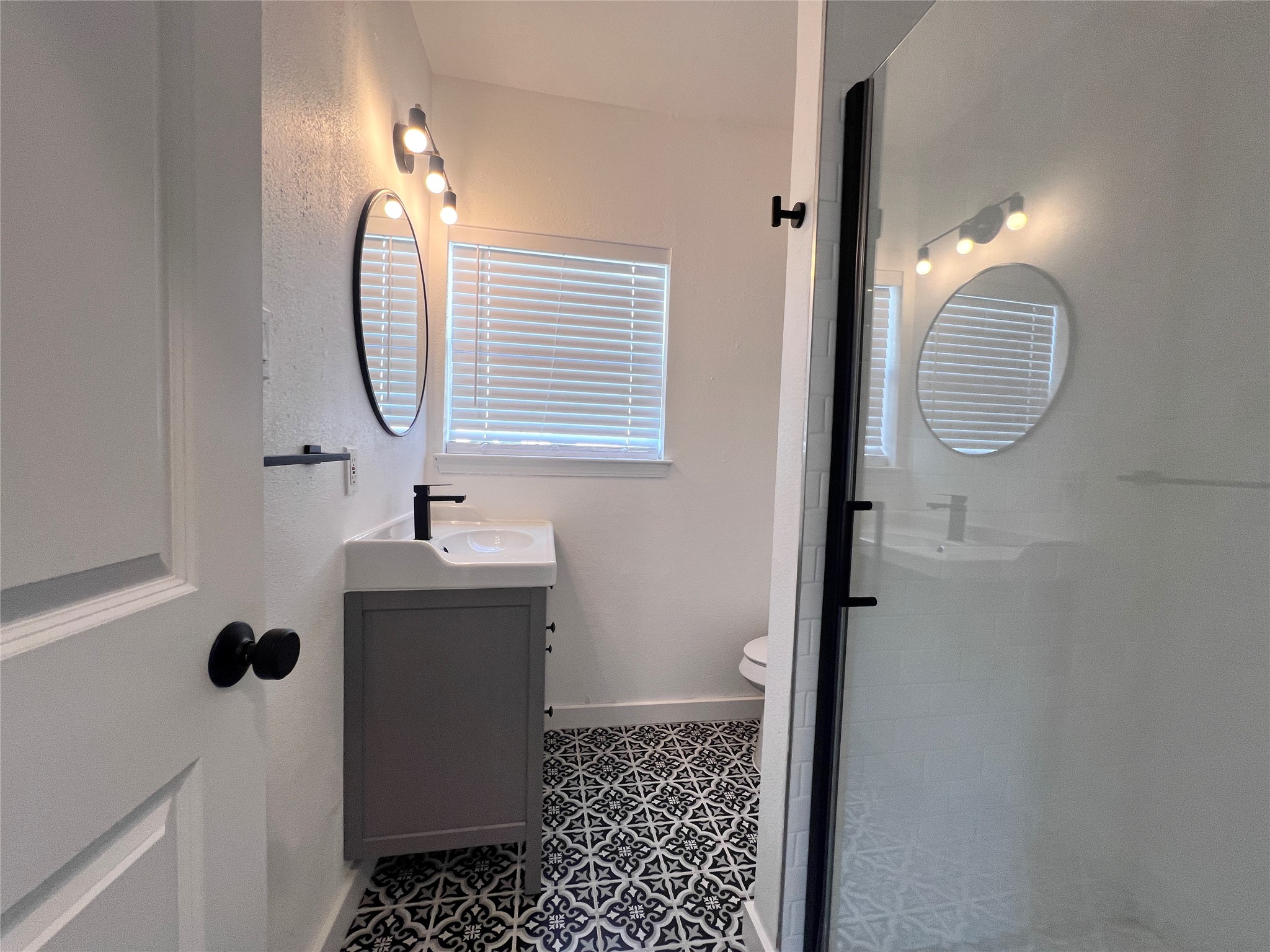 415 Fairview Street, Unit 6 Houston, TX 77006 - Photo 10 of 11 a bathroom with a sink a light fixture and a mirror