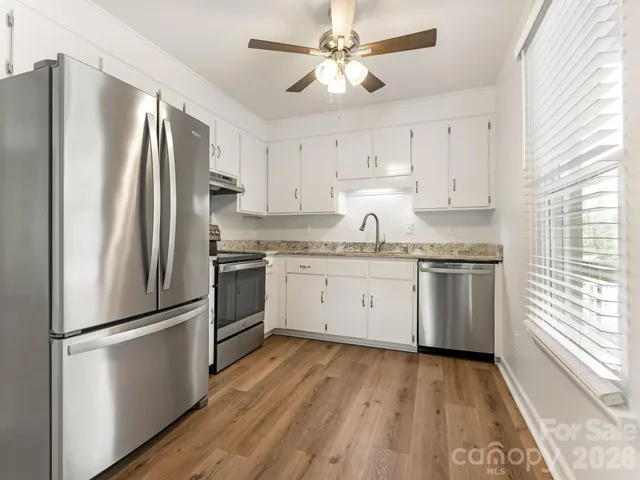 a kitchen with stainless steel appliances a refrigerator sink and cabinets