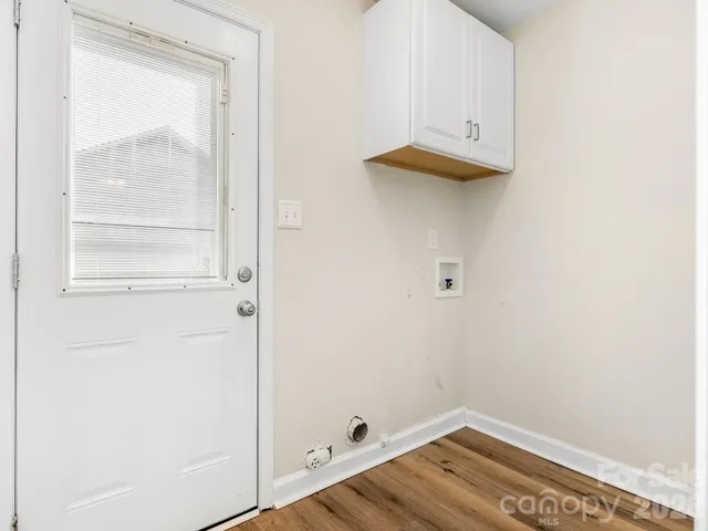 a view of a small space with wooden floor and a window