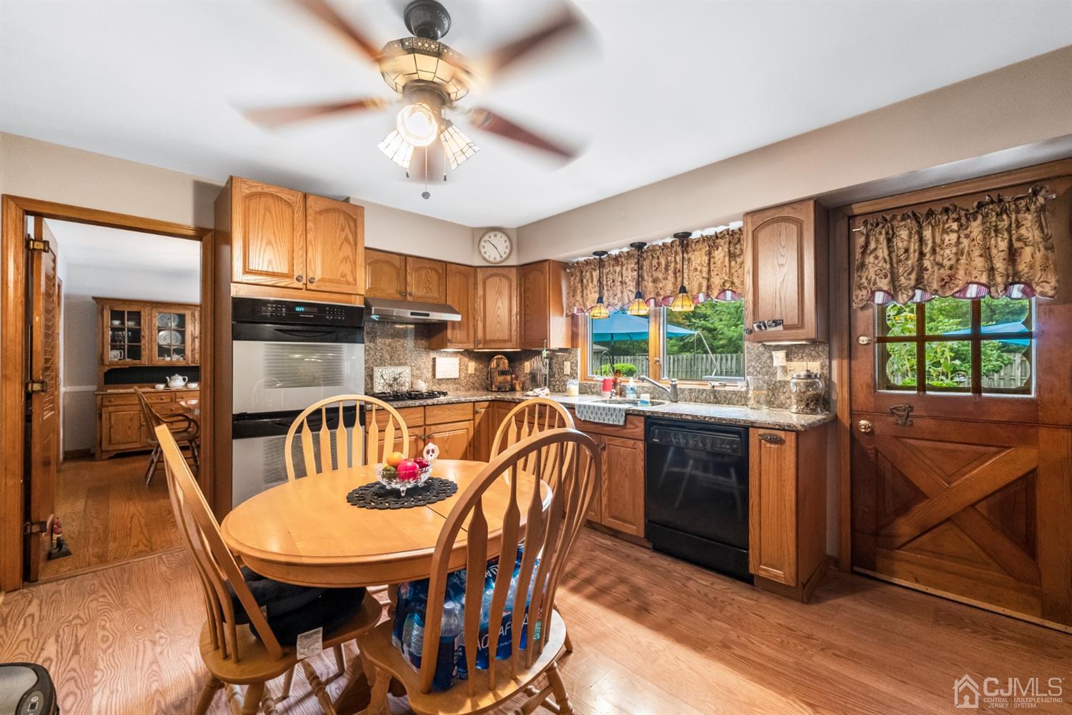 417 Ridge Road Dayton, NJ 08810 - Photo 15 of 37 a kitchen with stainless steel appliances granite countertop a stove a refrigerator a kitchen island stools a stove a dining table and chairs with wooden floor