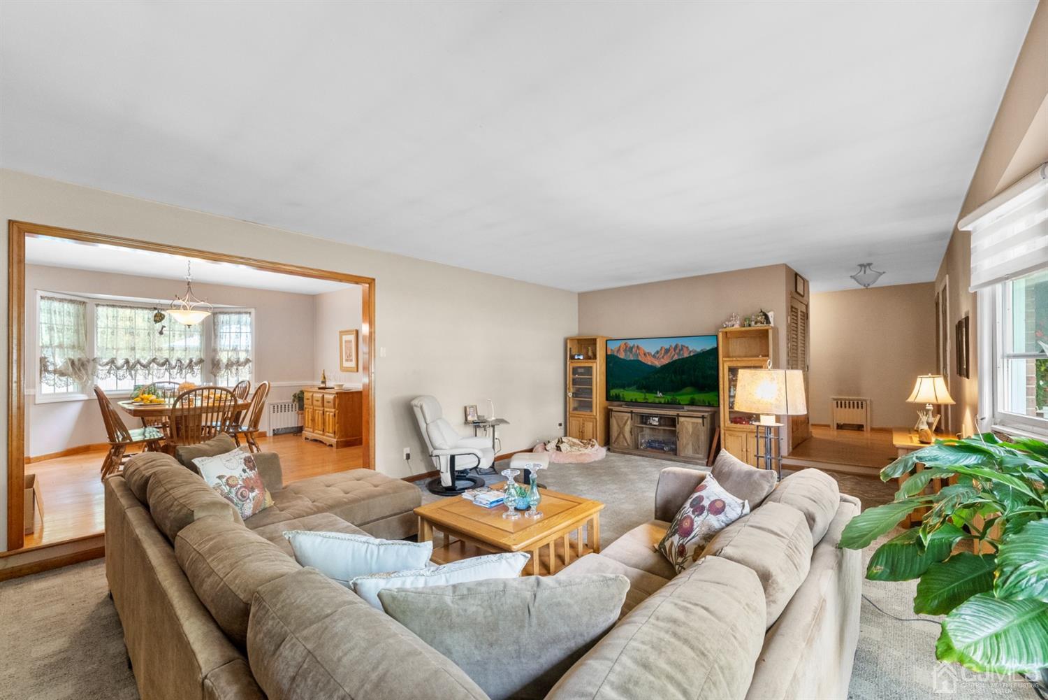 417 Ridge Road Dayton, NJ 08810 - Photo 10 of 37 a living room with furniture a flat screen tv and floor to ceiling window