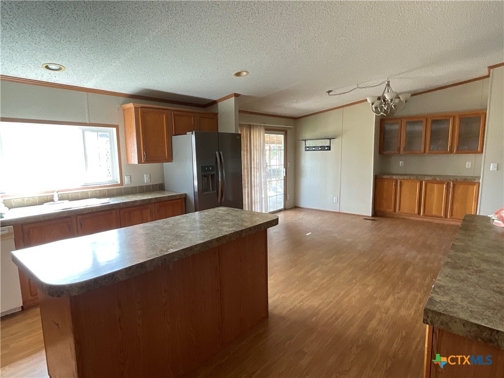 383 County Road 233 Hallettsville, TX 77964 - Photo 17 of 48 a living room with stainless steel appliances granite countertop a refrigerator a sink a barbeque oven and white cabinets next to a window