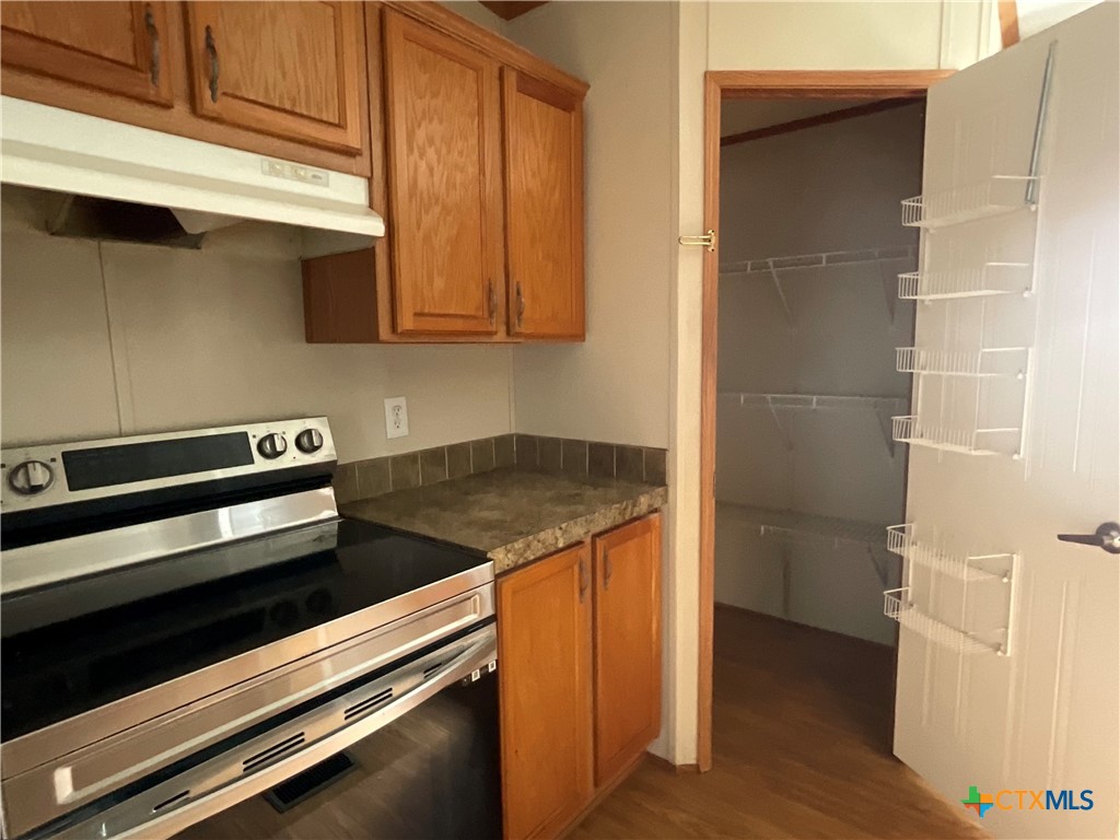 383 County Road 233 Hallettsville, TX 77964 - Photo 24 of 48 a kitchen with wooden cabinets and a stove top oven
