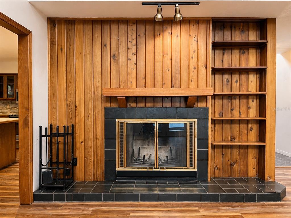 7119 Immokalee Road Keystone Heights, FL 32656 - Photo 11 of 50 a living room with a fireplace and a book shelf
