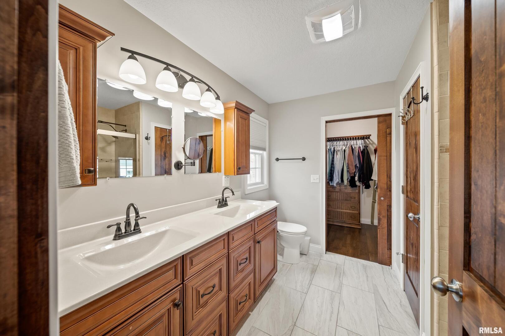 300 2nd Avenue Hampton, IL 61256 - Photo 12 of 32 a spacious bathroom with a double vanity sink a mirror and shower