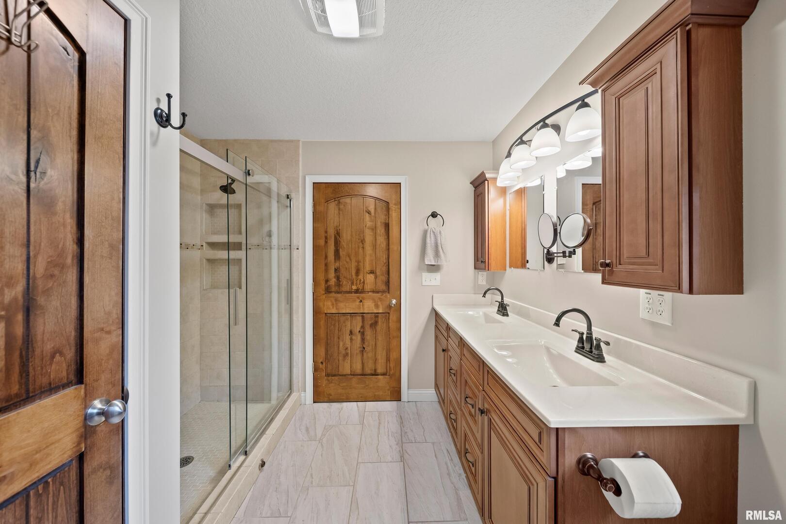 300 2nd Avenue Hampton, IL 61256 - Photo 14 of 32 a bathroom with a double vanity sink a mirror and shower