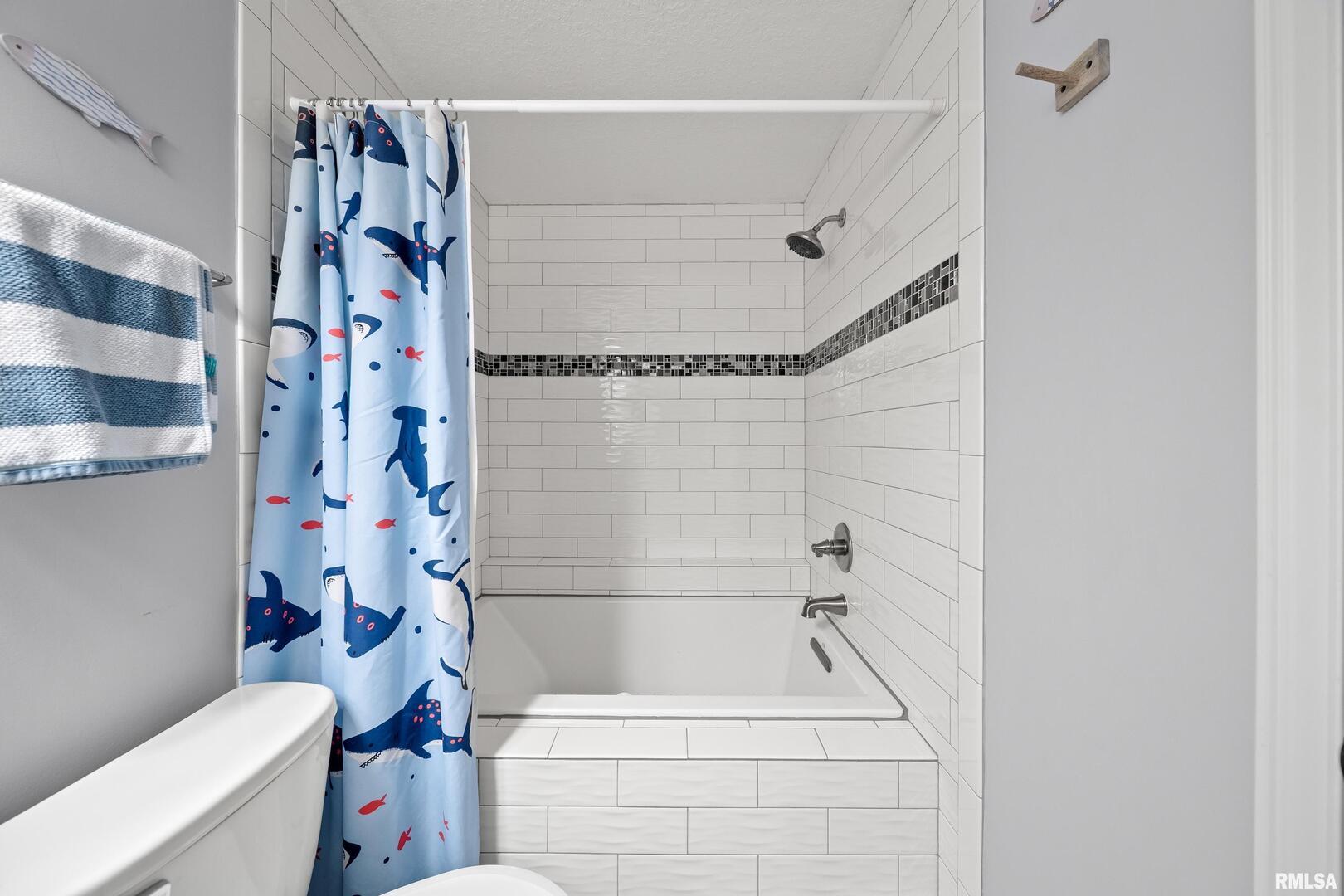 300 2nd Avenue Hampton, IL 61256 - Photo 22 of 32 a bathroom with a shower curtain and a toilet