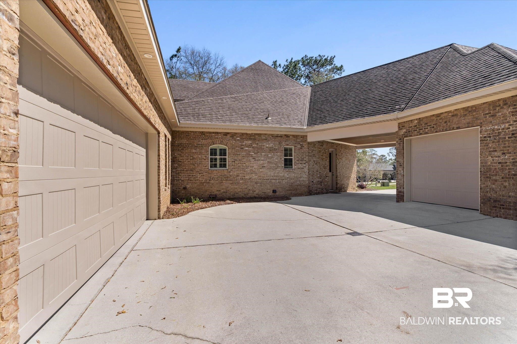 7676 Rockstone Lane Mobile, AL 36695 - Photo 41 of 47 View of side of property with a shingled roof, brick siding, concrete driveway, and a patio