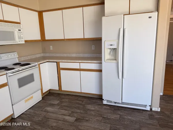 a kitchen with a refrigerator sink and cabinets